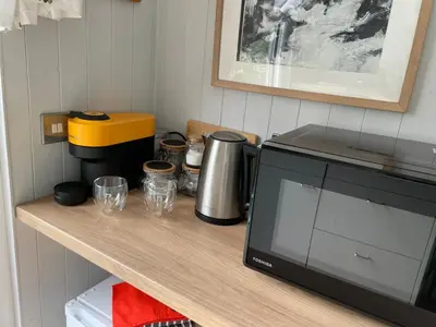 a counter with a coffee maker and a microwave at Penrallt Bach in Blaenau-Ffestiniog