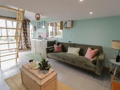 a living room with a couch and a kitchen at Penrallt Bach in Blaenau-Ffestiniog