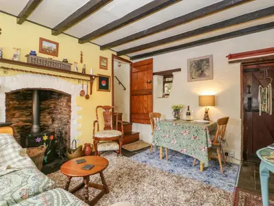 a living room with a table and a fireplace at Violet Cottage in Llangammarch Wells