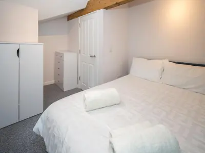 a bedroom with a white bed and a white cabinet at 2 bedroom home within walking distance of the town - Pass the Keys in Shrewsbury
