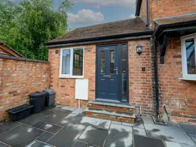 a brick house with a blue door on a patio at 2 bedroom home within walking distance of the town - Pass the Keys in Shrewsbury
