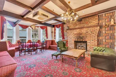a living room with a fireplace and a brick wall at White Waters Bed and Breakfast in Llangollen