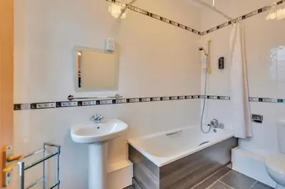 a white bathroom with a sink and a tub at White Waters Bed and Breakfast in Llangollen