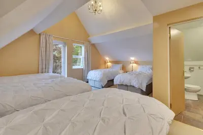 a attic bedroom with two beds and a bathroom at White Waters Bed and Breakfast in Llangollen