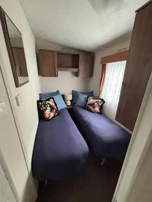 a small room with two beds in a trailer at Modern 2017 model Delta Sienna static caravan in Clarach Bay in Aberystwyth