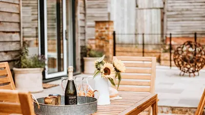 a table with a bottle of wine and flowers on it at The Piggery in Yarpole