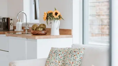 a kitchen with a white couch and a vase with flowers at The Piggery in Yarpole