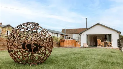 a large metal object in the grass in front of a house at The Old Dairy in Yarpole