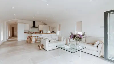 a white living room with a couch and a table at The Old Dairy in Yarpole