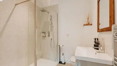a bathroom with a shower and a sink at The Old Dairy in Yarpole