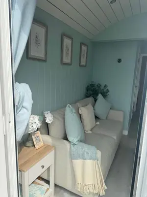 a living room with a couch and a table at Bay View shepherds hut with hot tub in Llanfair