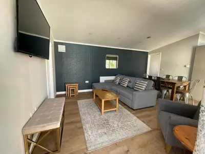 a living room with a couch and a table at Derw View Green Lodge in Aberystwyth