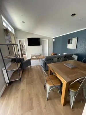 a living room with a table and a couch at Derw View Green Lodge in Aberystwyth