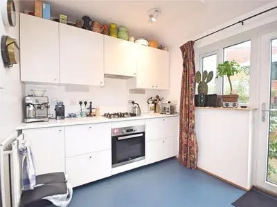 a kitchen with white cabinets and a window at Georgian Terrace Town House in Mid Wales in Newtown