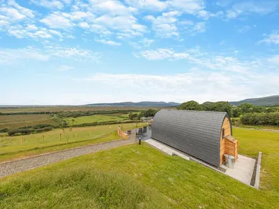 a large metal building on top of a green field at Dyfi - Uk46064 in Llancynfelyn