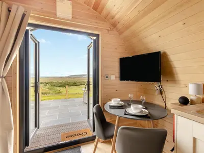 a small dining room with a table and a large window at Dyfi - Uk46064 in Llancynfelyn