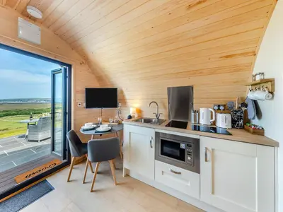 a kitchen in a tiny house with a table and chairs at Leri - Uk46065 in Llancynfelyn