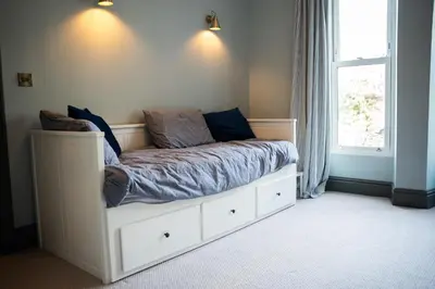 a bedroom with a white bed with a window at Haulfryn in Barmouth