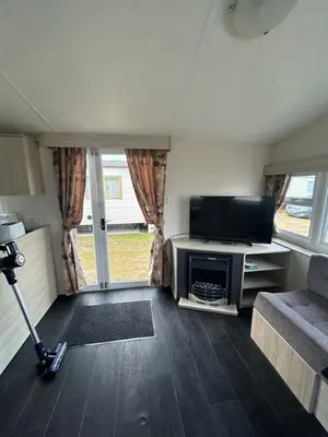 a small living room with a tv and a couch at Caravan in Barmouth in Llanddwywe