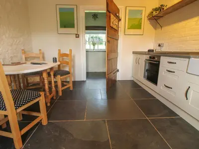 a kitchen with a table and chairs and a counter top at The Mytton at Mill Barn in Craven Arms