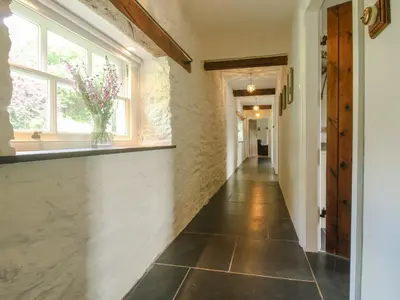 a hallway with a vase of flowers in a window at The Mytton at Mill Barn in Craven Arms
