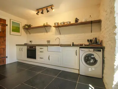 a kitchen with a washer and a washing machine at The Mytton at Mill Barn in Craven Arms