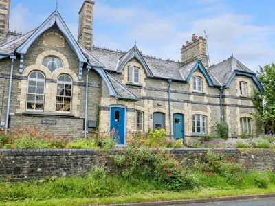 an old stone house with blue doors and windows at Teacher's Cottage in Presteigne