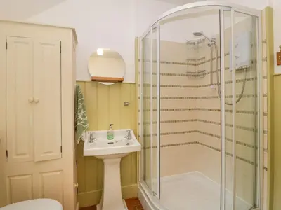 a bathroom with a shower and a sink at Teacher's Cottage in Presteigne