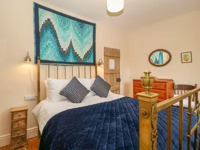 a bedroom with a bed and a painting on the wall at Teacher's Cottage in Presteigne