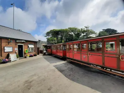 a red train is parked at a train station at Dysynni Pod in Tywyn