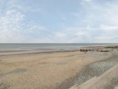 two benches on a beach with the ocean at Dysynni Pod in Tywyn