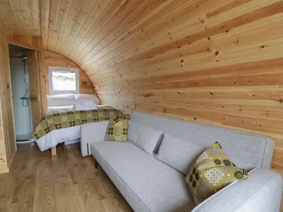 a living room with a couch and a bed at Dysynni Pod in Tywyn