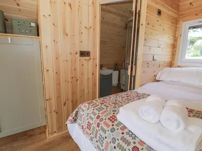 a bedroom with a bed with towels on it at Tarrenhendre Pod in Tywyn