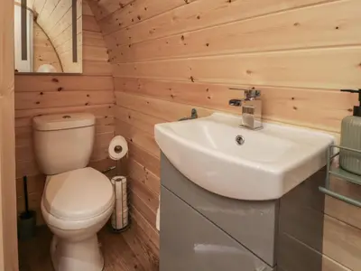 a bathroom with a toilet and a sink at Tarrenhendre Pod in Tywyn