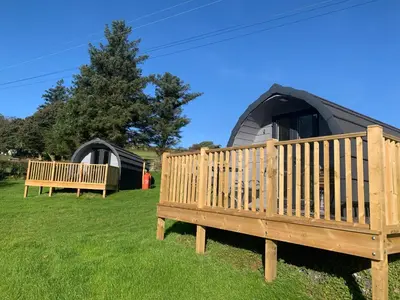 a couple of benches in front of a yurt at Tarrenhendre Pod in Tywyn