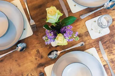 a table with white plates and flowers on it at The Little Cygnet in Shrewsbury