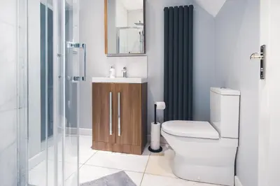 a bathroom with a toilet and a sink and a shower at The Little Cygnet in Shrewsbury