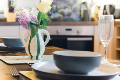 a table with a vase of flowers and a bowl at The Little Cygnet in Shrewsbury