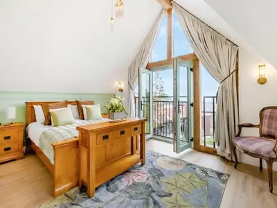 a bedroom with a bed and a balcony at Private Lodge with Spa and Sauna in Shrewsbury