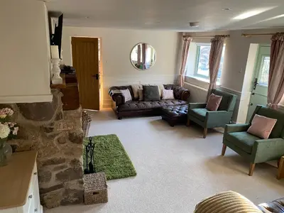 a living room with a couch and two chairs at Private Lodge with Spa and Sauna in Shrewsbury