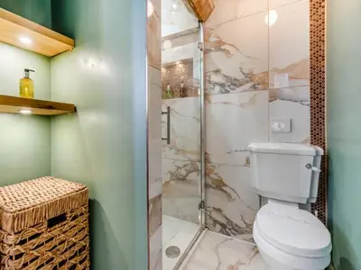a bathroom with a toilet and a glass shower at Private Lodge with Spa and Sauna in Shrewsbury