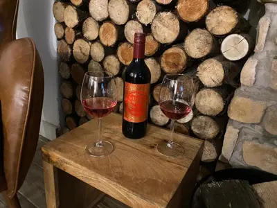 a bottle of wine and two glasses on a table at Private Lodge with Spa and Sauna in Shrewsbury