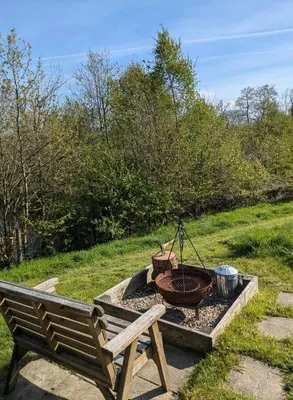 a park bench sitting next to a fire pit at Go Eco Glamping in Lampeter