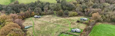 an aerial view of a house in a field with trees at Go Eco Glamping in Lampeter