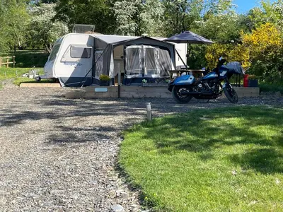 a motorcycle parked next to a trailer and a tent at Pantyronen tourer holidays in Llanbadarn-fynydd