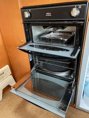 an oven with its door open in a kitchen at Pantyronen tourer holidays in Llanbadarn-fynydd