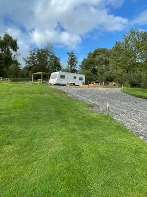 a white trailer parked on a gravel road at Pantyronen tourer holidays in Llanbadarn-fynydd