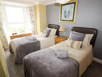 a bedroom with two beds and a window at Morva in New Quay