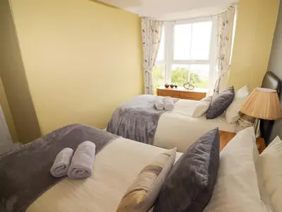 a bedroom with two beds and a window at Morva in New Quay