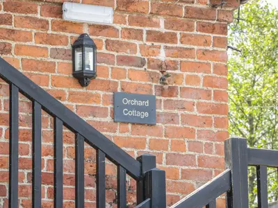 a brick wall with a street sign on it at Orchard Cottage in Newtown